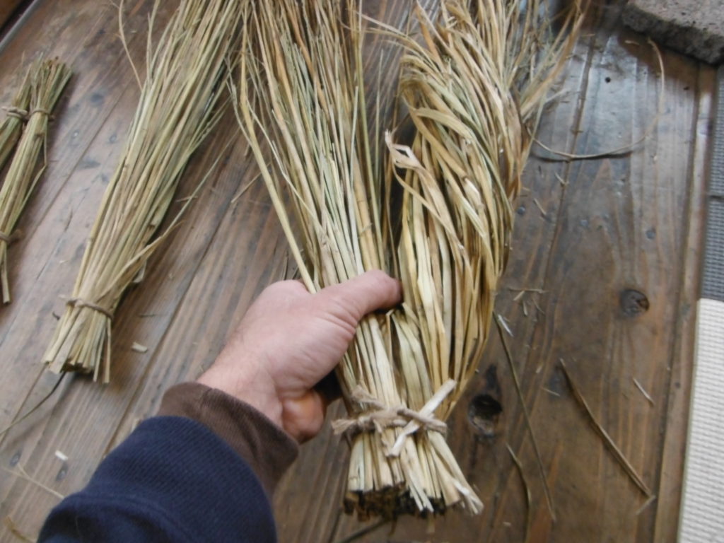 稲藁の束をねじっていく。