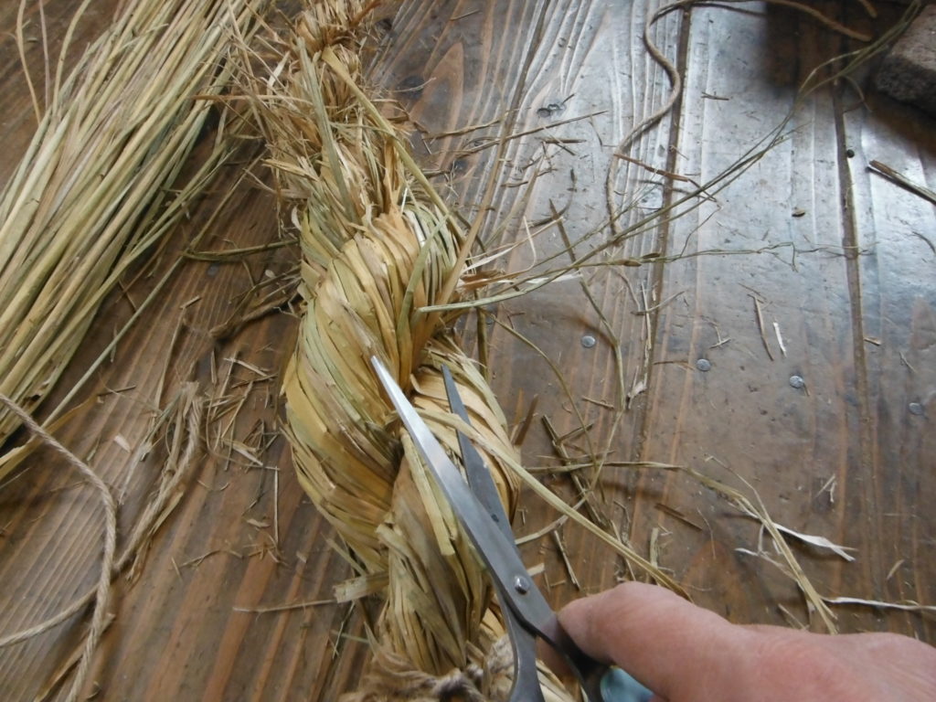 飛び出た藁をハサミで切る。