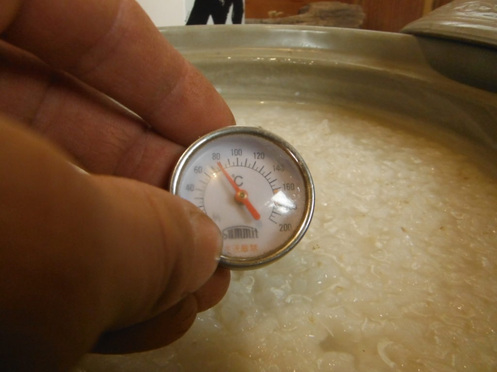 鍋の中のお粥に温度計が８０度を示す。