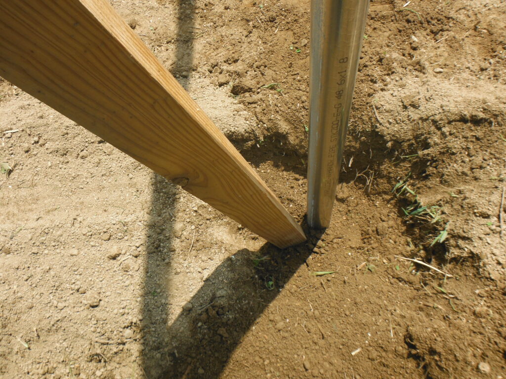 単管パイプの柱を埋めていく。