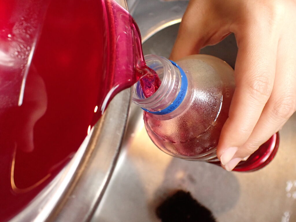 赤紫蘇濃縮液をペットボトルに詰める。