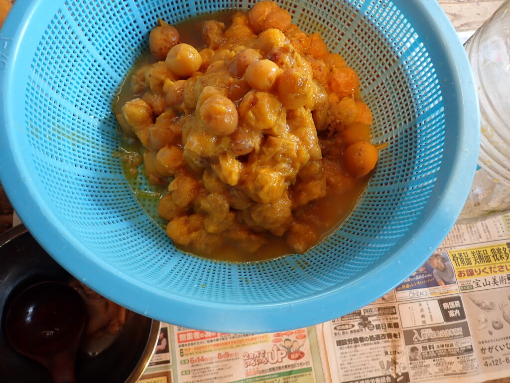 お酢を仕込んだ梅をザルで濾す。