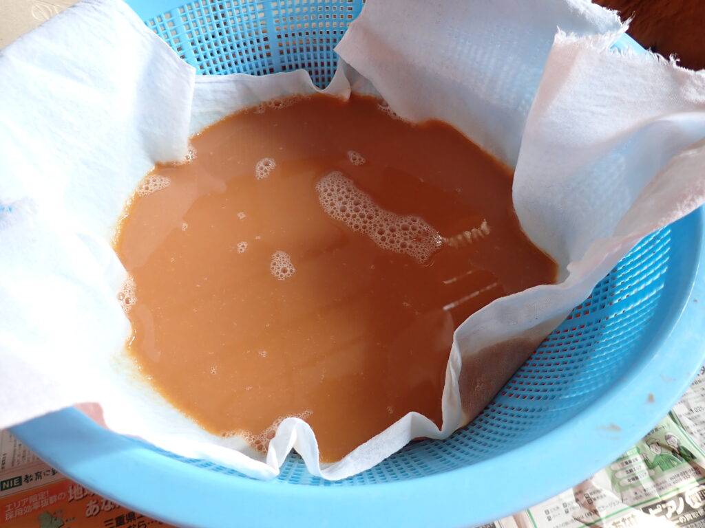 ビワ酢をサラシで濾す。